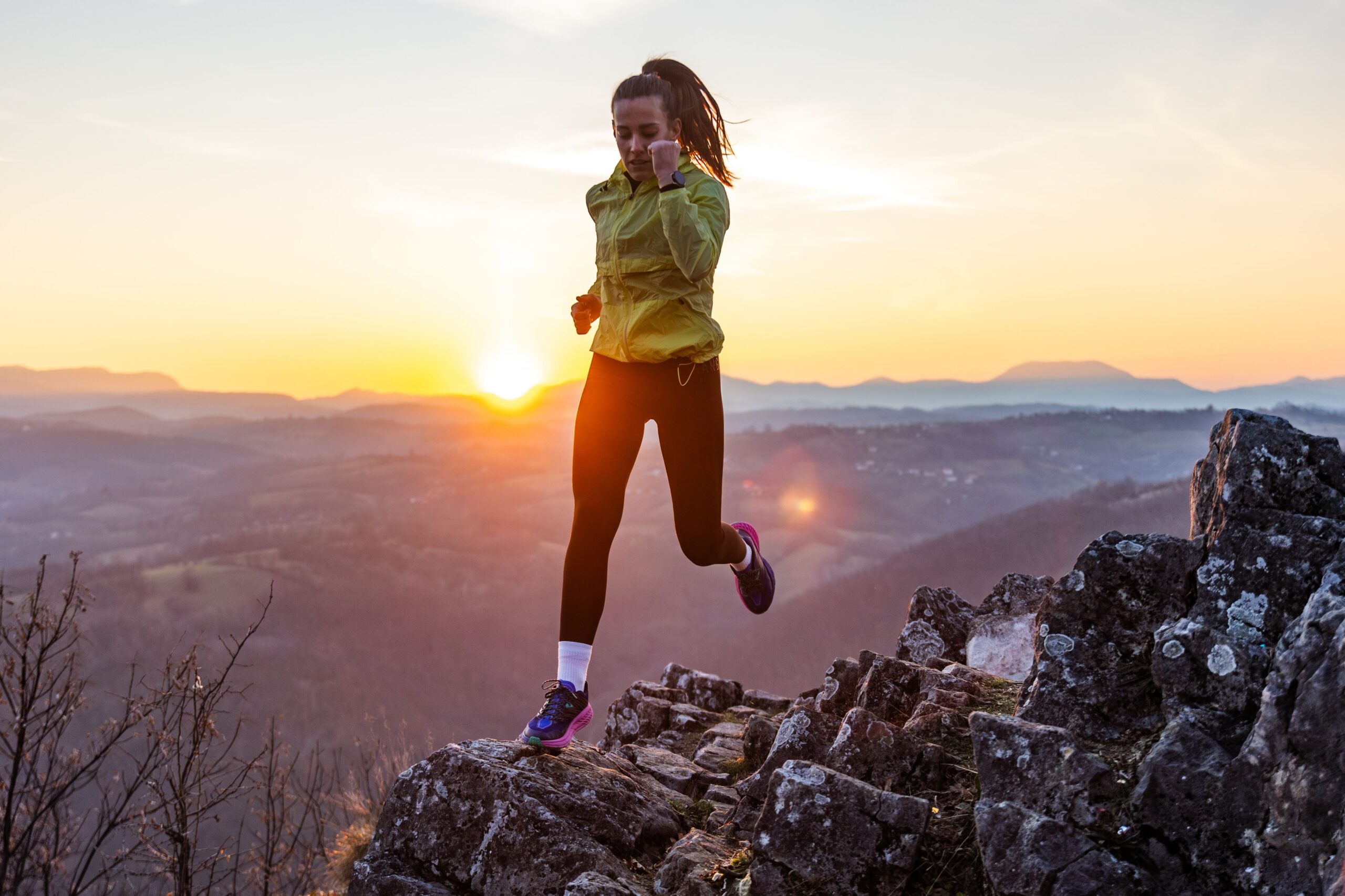 A,Young,Woman,In,Sportswear,Running,On,A,Rocky,Hilltop